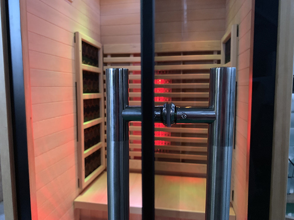 Lumin One infrared sauna, interior through the open glass door showing the heaters and bench