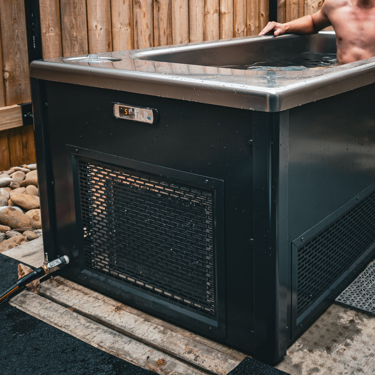 Summit all-in-one cold plunge installed outdoors against a timber fence, in use