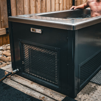 Summit all-in-one cold plunge installed outdoors against a timber fence, in use
