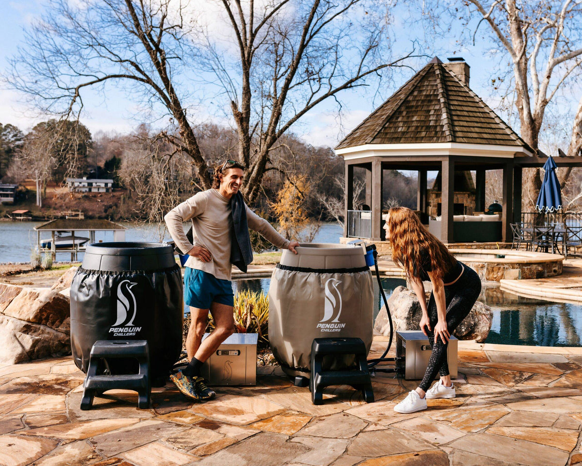 Two wrapped barrels with Penguin cold therapy chillers on a lakeside patio
